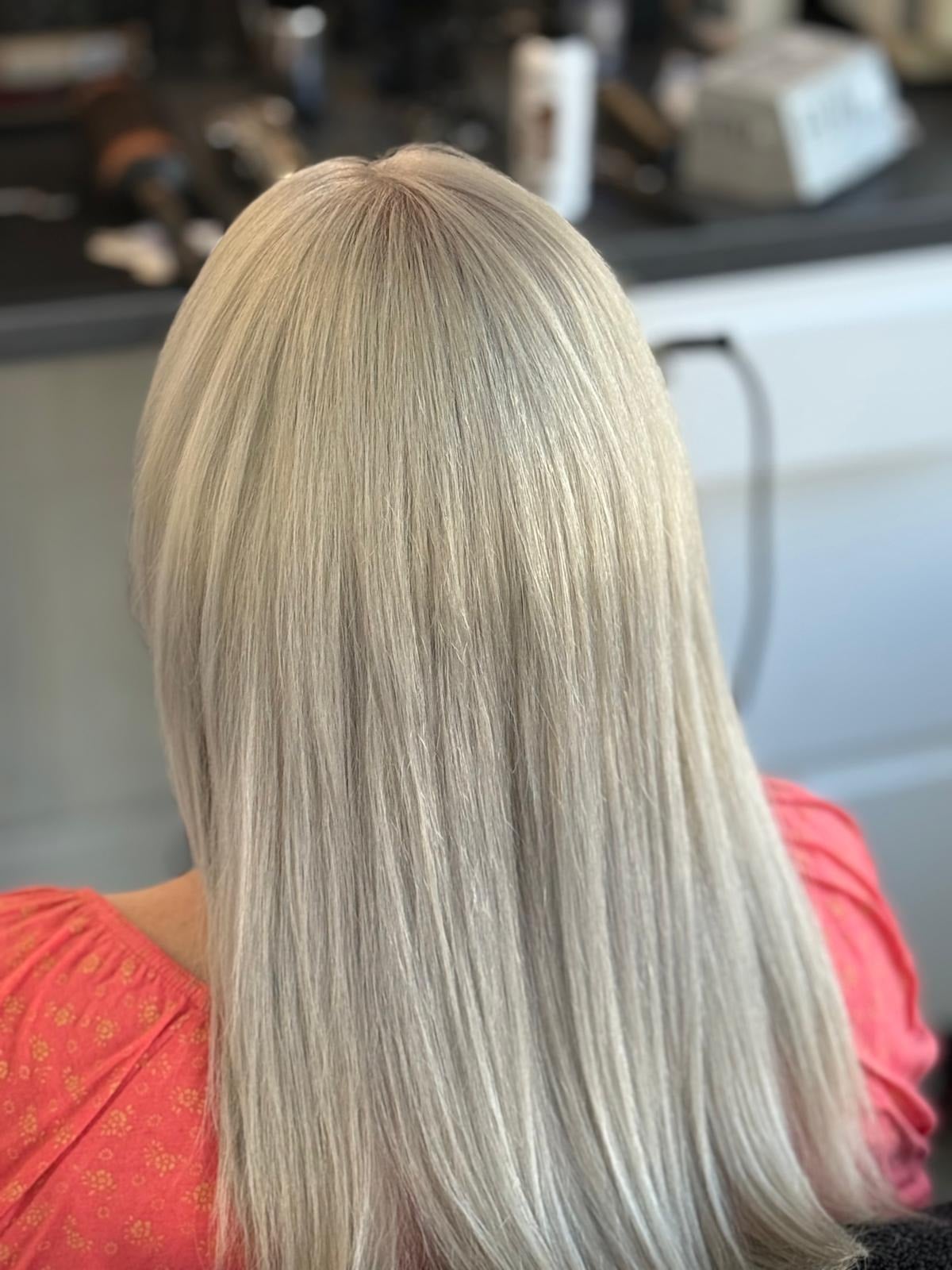 Păr lung, drept, vopsit blond platinat, văzut din spate