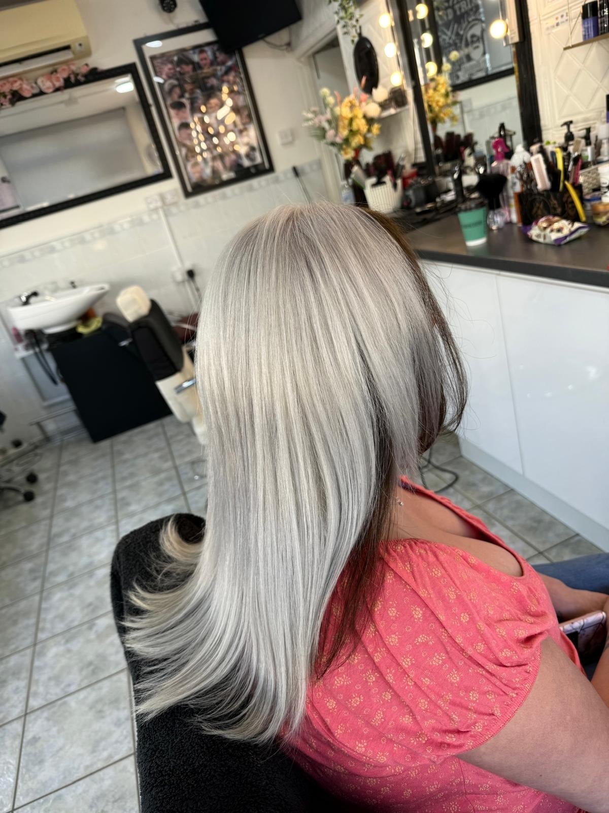 Blond platinat cu reflexe argintii pe păr lung, în salon